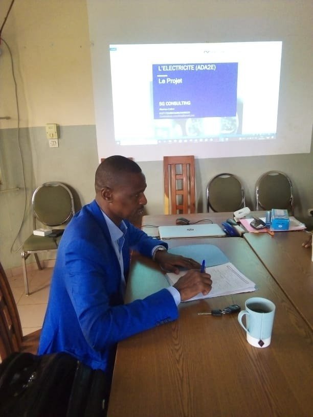 Dr Ismaïla IMOROU ISSA prenant des notes pendant une présentation de projet